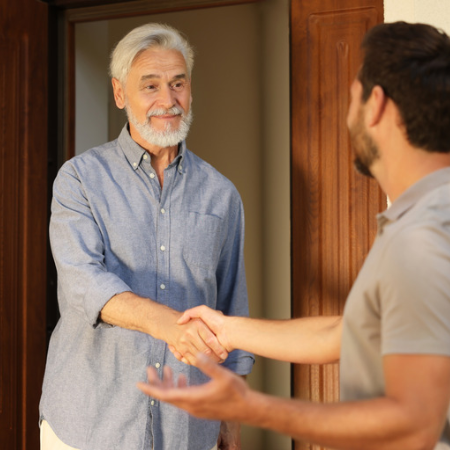 Image of a man shaking the hand of his neighbor.